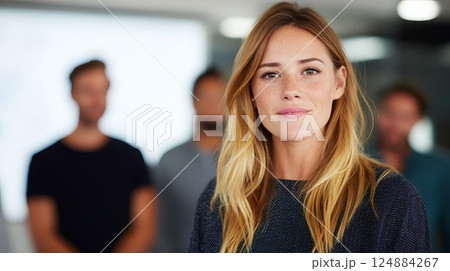 Confident Female Entrepreneur Giving Presentation in Modern Office Setting with Colleagues 124884267
