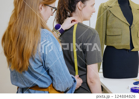 Atelier sewing workshop. female seamstress, fashion designer, takes measurements . 124884826
