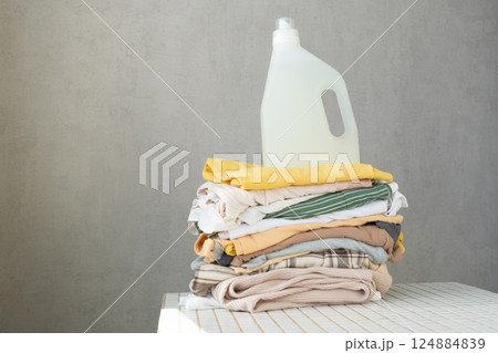 mock up, conditioner, or laundry gel against stack of clean clothes on a table with tulip flowers. mock up, conditioner, or laundry gel against stack of clean clothes on a table with tulip flowers. 124884839