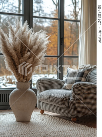 Elegant decorative vase with pampas grass beside a cozy couch in a serene winter setting Elegant decorative vase with pampas grass beside a cozy couch in a serene winter setting 124885489