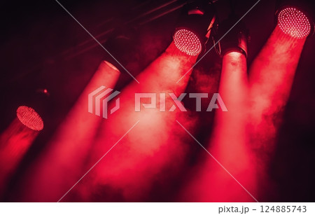 Intense red stage lights illuminate foggy atmosphere during live performance Intense red stage lights illuminate foggy atmosphere during live performance 124885743