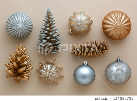 Decorative Christmas ornaments in gold and silver colors arranged on a light background Decorative Christmas ornaments in gold and silver colors arranged on a light background 124885789