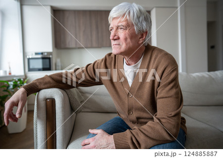 Despondent depressed senior with memory loss gazes into distance at home, dementia and fear 124885887