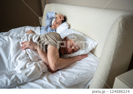 Upset angry wife lies in bed after argument watching husband who fell asleep ignoring conflict Upset angry wife lies in bed after argument watching husband who fell asleep ignoring conflict 124886224