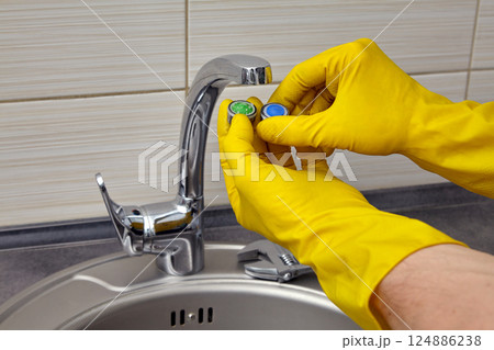 replacing a clogged faucet aerator in the kitchen sink replacing a clogged faucet aerator in the kitchen sink 124886238