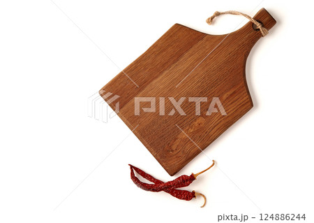 wooden cutting board and dried chili pepper pods isolated on white background. top view with copy space 124886244