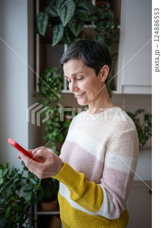 Joyful smiling female browse social media in smartphone, messaging, web feed, delivery ordering 124886553