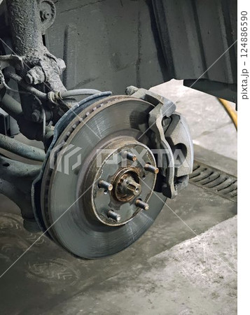 Car brake disc being inspected during maintenance in auto repair shop 124886590