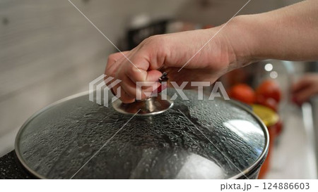 There is hot water in the pan, the pickles are prepared for rolling into jars. The process of salting jars, preparing for winter. The process of canning tomatoes for the winter. 124886603