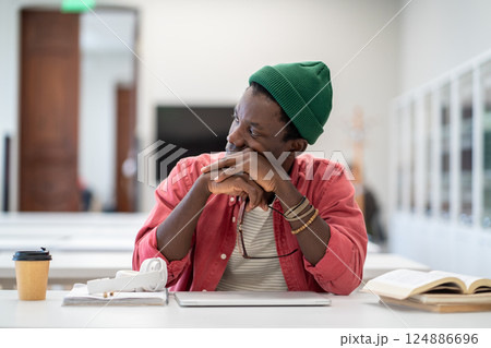 Serious African American student man tired of studying after learning difficult homework on laptop.  124886696