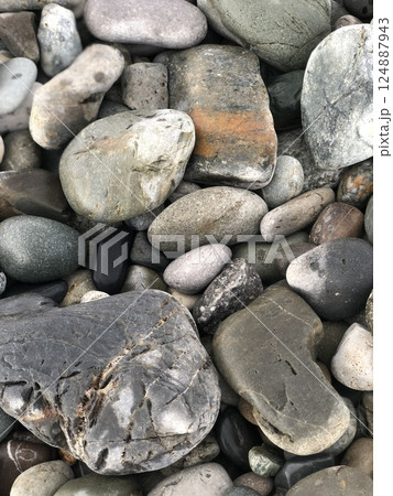 Beach pebble vertical shot for wallpaper, cover, banner, texture. Beautiful pebbles close-up. Natural sea stone background. 124887943