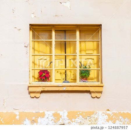 A yellow window with closed shutters behinde the frame A yellow window with closed shutters behinde the frame 124887957