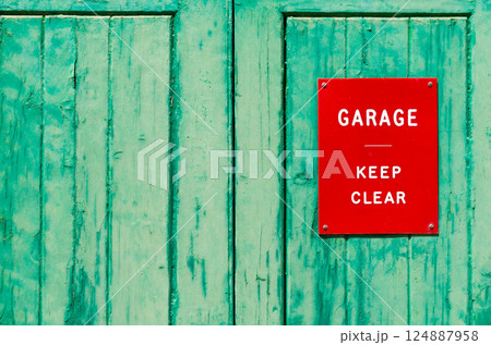 Old green wooden garage doors with a red sign - keep clear Old green wooden garage doors with a red sign - keep clear 124887958