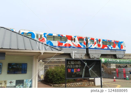 万博記念公園駅を出るミャクミャクカラーの大阪モノレール 124888095