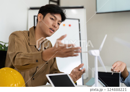 Sustainable Energy and Innovation. A professional discussing renewable energy solutions with a focus on wind power. 124888221