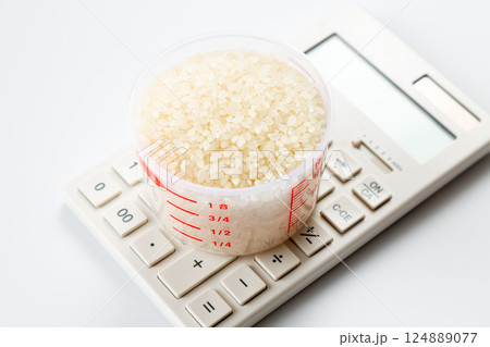 計量カップに入った米と電卓 124889077