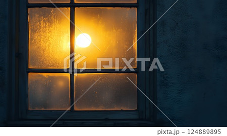 Window with a light shining through it. The light is yellow. The window is foggy 124889895