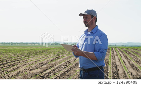 Businessman digital agricultural farmer with tablet. Professional businessman farmer male guy with serious focused look using technological digital tablet for efficient agricultural agrarian business. Businessman digital agricultural farmer with tablet. Professional businessman farmer male guy with serious focused look using technological digital tablet for efficient agricultural agrarian business. 124890409