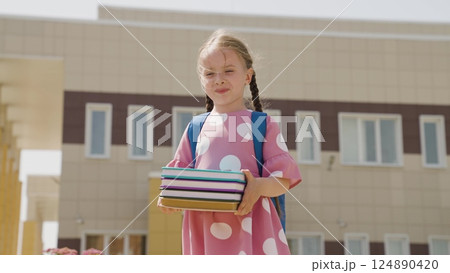 child kid girl reading books, child holding books her hands background school building, campus child studying, school backpack back first grader, concept children educational life, thirst reading kid 124890420