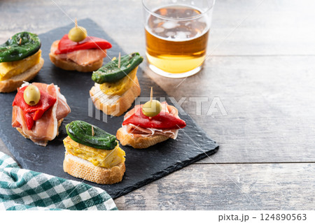 Traditional Spanish pintxos on wooden table Traditional Spanish pintxos on wooden table 124890563
