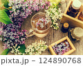 Essential oil and a cup of tea made from lilac flowers 124890768