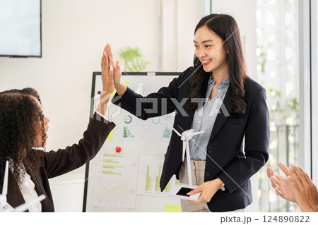 Empowering Change and Team Success. A professional receives high-fives during a presentation focused on sustainable energy solutions. Empowering Change and Team Success. A professional receives high-fives during a presentation focused on sustainable energy solutions. 124890822