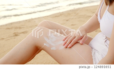 Beautiful Asian woman apply sun protection cream on tanned on leg at tropical beach with white sand, Sun Cream Skincare, Close up female in bikini using sunscreen lotion on back body before sunbathing Beautiful Asian woman apply sun protection cream on tanned on leg at tropical beach with white sand, Sun Cream Skincare, Close up female in bikini using sunscreen lotion on back body before sunbathing 124891651