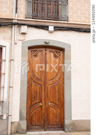 Elegant wooden door with stone frame on classic european building 124892090