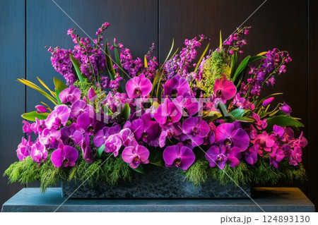 Vibrant arrangement of purple orchids and greenery in modern display at a luxury venue 124893130