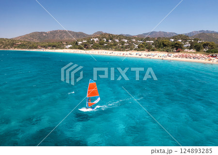 Aerial view of windsurfer on blue sea at sunny summer day Aerial view of windsurfer on blue sea at sunny summer day 124893285