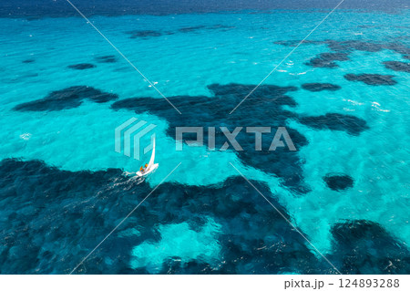 Aerial view of sailboat on blue sea on summer sunny day. Travel Aerial view of sailboat on blue sea on summer sunny day. Travel 124893288