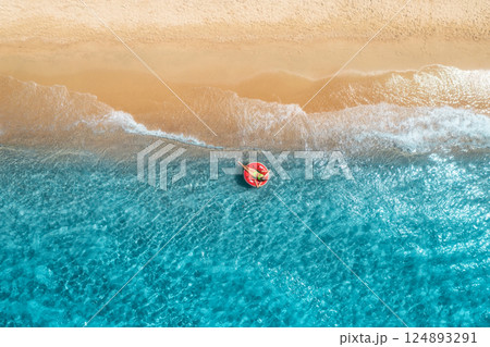 Aerial view of a young woman swimming with red swim ring 124893291