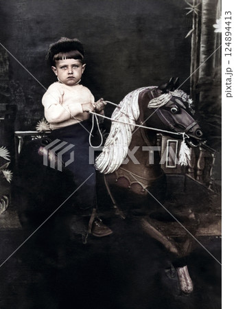 Vintage portrait of a little boy riding a wooden horse. Retro photo from 1940. Vintage portrait of a little boy riding a wooden horse. Retro photo from 1940. 124894413
