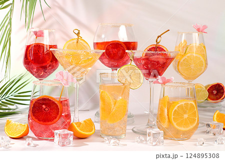 Banner with various glasses of alcoholic drinks and tropical fruits. Cocktails from fruits, ice cubes, rum and tequila. Summer party and relaxation concept. Menu for a bar or cafe 124895308