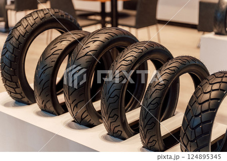 Motorcycle racing tire display in store. Black rubber tires for scooters on track 124895345