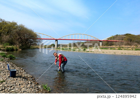 ウェーダーを履いて、タモで川虫を捕るつり人 124895942