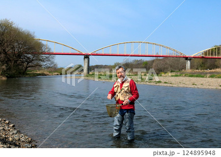 ウェーダーを履いて、タモで川虫を捕るつり人 124895948