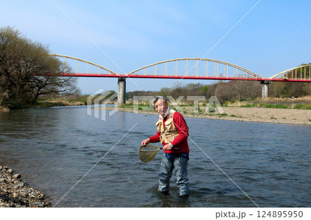 ウェーダーを履いて、タモで川虫を捕るつり人 124895950