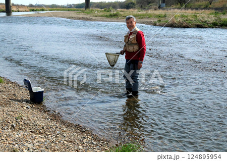 ウェーダーを履いて、タモで川虫を捕るつり人 124895954