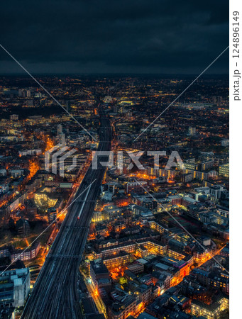 Aerial night view of east London, wide railway track with one train on it in middle Aerial night view of east London, wide railway track with one train on it in middle 124896149