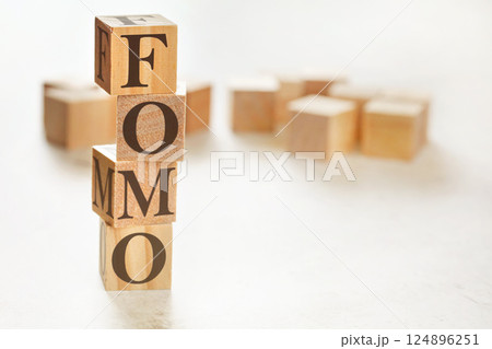 Four wooden cubes arranged in stack with letters FOMO (meaning Fear of Missing Out) on them, space for text / image at down right corner Four wooden cubes arranged in stack with letters FOMO (meaning Fear of Missing Out) on them, space for text / image at down right corner 124896251
