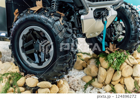 off-road quad bike wheel on a pile of rocks. off-road studded tire on mountain boulders off-road quad bike wheel on a pile of rocks. off-road studded tire on mountain boulders 124896272