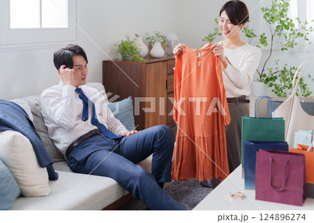 服を買う浪費家の妻と怒る夫（夫婦喧嘩） 124896274