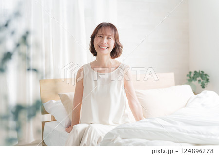 朝ベッドから起床する中高年女性 124896278