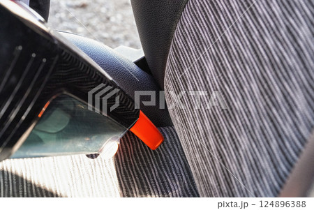Car interior - seats, cleaned from dust with small orange portable vacuum cleaner 124896388