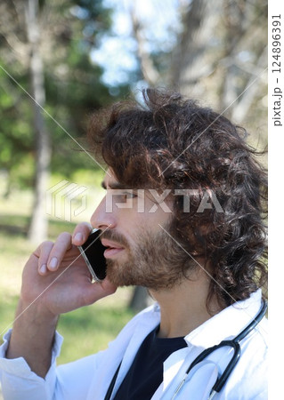 Long Hair Male Doctor Talks On The Phone Bad News Outside The Hospital Long Hair Male Doctor Talks On The Phone Bad News Outside The Hospital 124896391