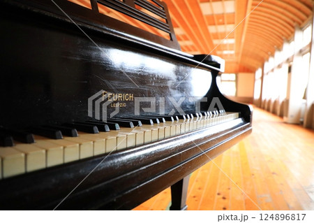 体育館に静かに置かれた大正時代のアンティークピアノ（日本 愛媛県西予市） 124896817