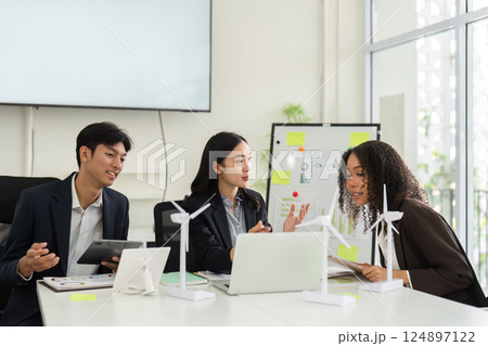 Collaborative ESG Strategy Discussion. Team members evaluate sustainable practices and strategies in a modern office. 124897122