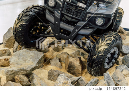 off-road quad bike wheel on a pile of rocks. off-road studded tire on mountain boulders off-road quad bike wheel on a pile of rocks. off-road studded tire on mountain boulders 124897242