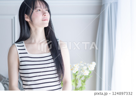 爽やかなタンクトップ姿でパソコンを使う若い女性 124897332
